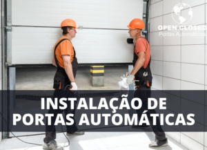 Dois técnicos instalando uma porta automática em um ambiente industrial.